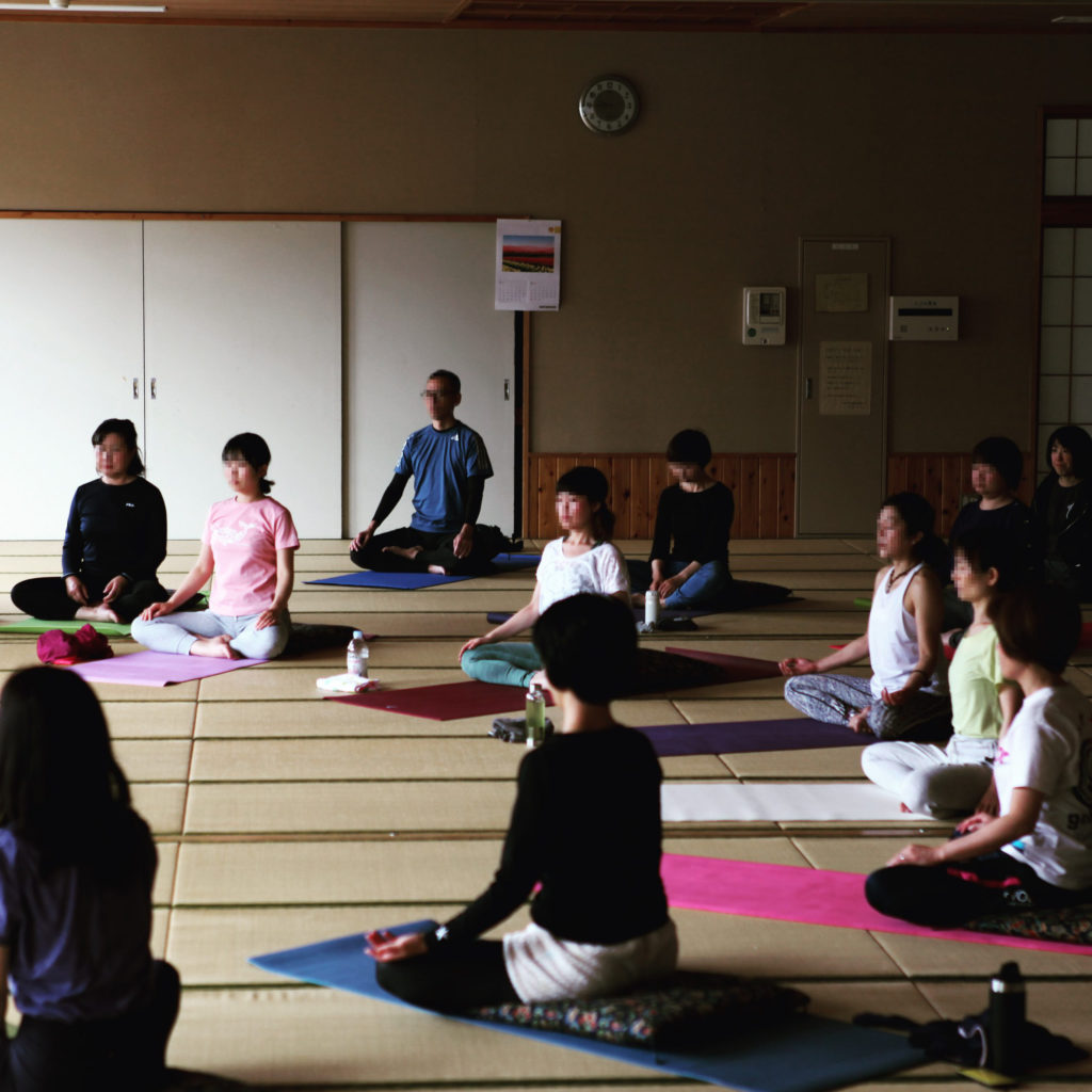 東松山ヨガの瞑想のクラス。25人が目を閉じあぐらで座っている様子。