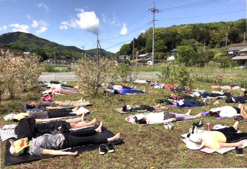 ときがわ町の有機農家晴耕雨読さんで行われた畑ヨガで土の上に寝転がる参加者の方々